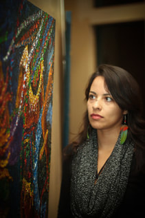  Artist Elizabeth Jiménez Montelongo looking at her oil painting.